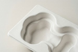 Close-up of a premium wet-pressed molded pulp tray showing smooth surface and fine fibers.
