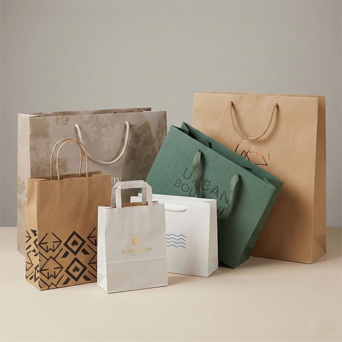 Assorted custom printed paper bags in various sizes, materials, finishes, and handle styles for retail and gift packaging.