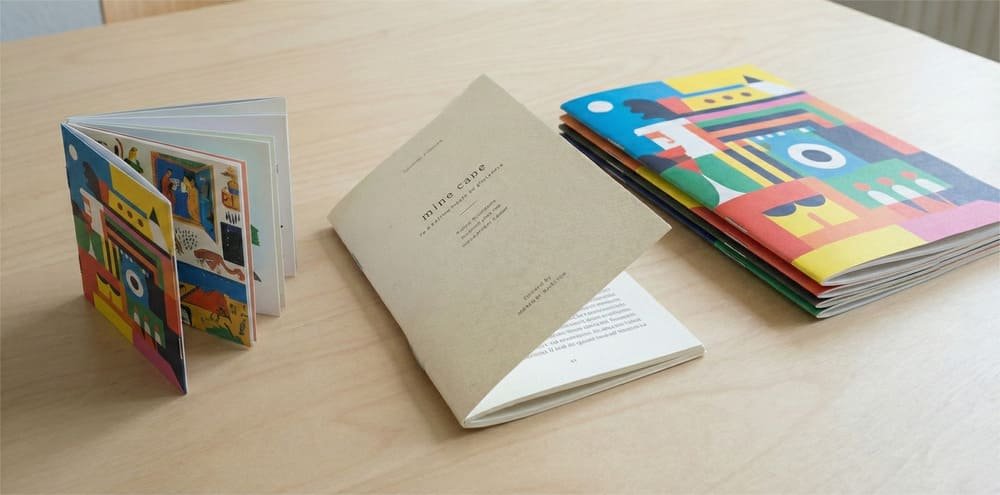 A collection of saddle stitch booklets with different designs and sizes, showcasing a cost-effective binding method.