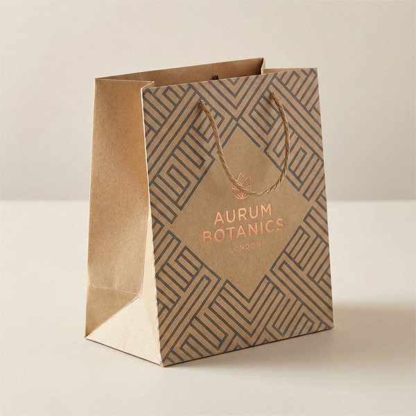 Square-bottom paper bag with reinforced base, side gussets, eco-friendly rope handles, and custom printed branding shown standing on a neutral studio surface.